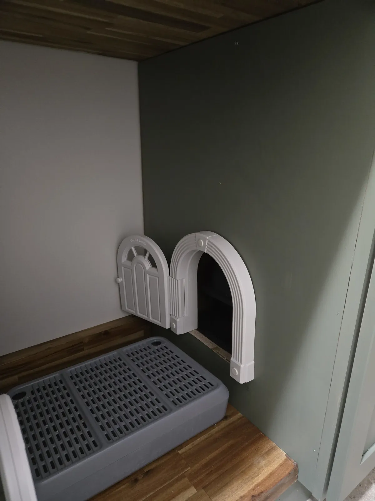 Close-up of the Purrfect Portal Meow Manor XL cat door installed in the cabinet side panel, with Gorilla Grip liner protecting the walls