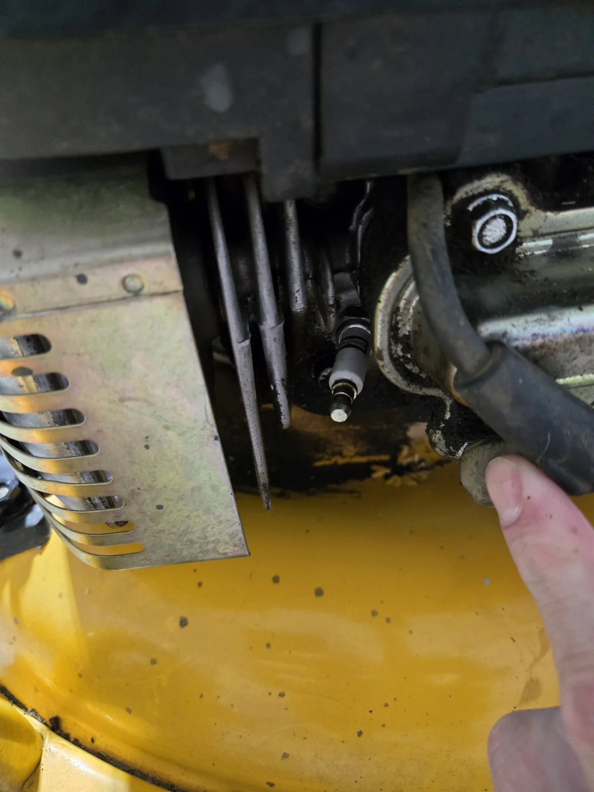 Pulling the old spark plug — wire boot pulled off, plug exposed for socket access