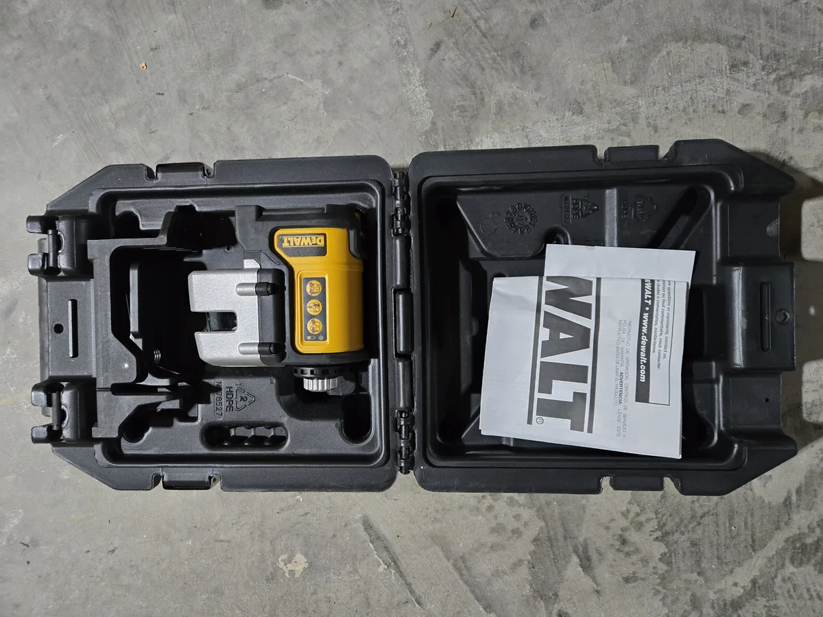 DeWalt laser level sitting in its hard carrying case with manual