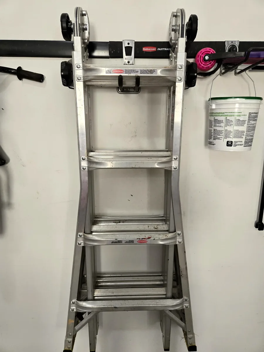 Multi-position ladder and extension cords hanging on FastTrack utility hooks