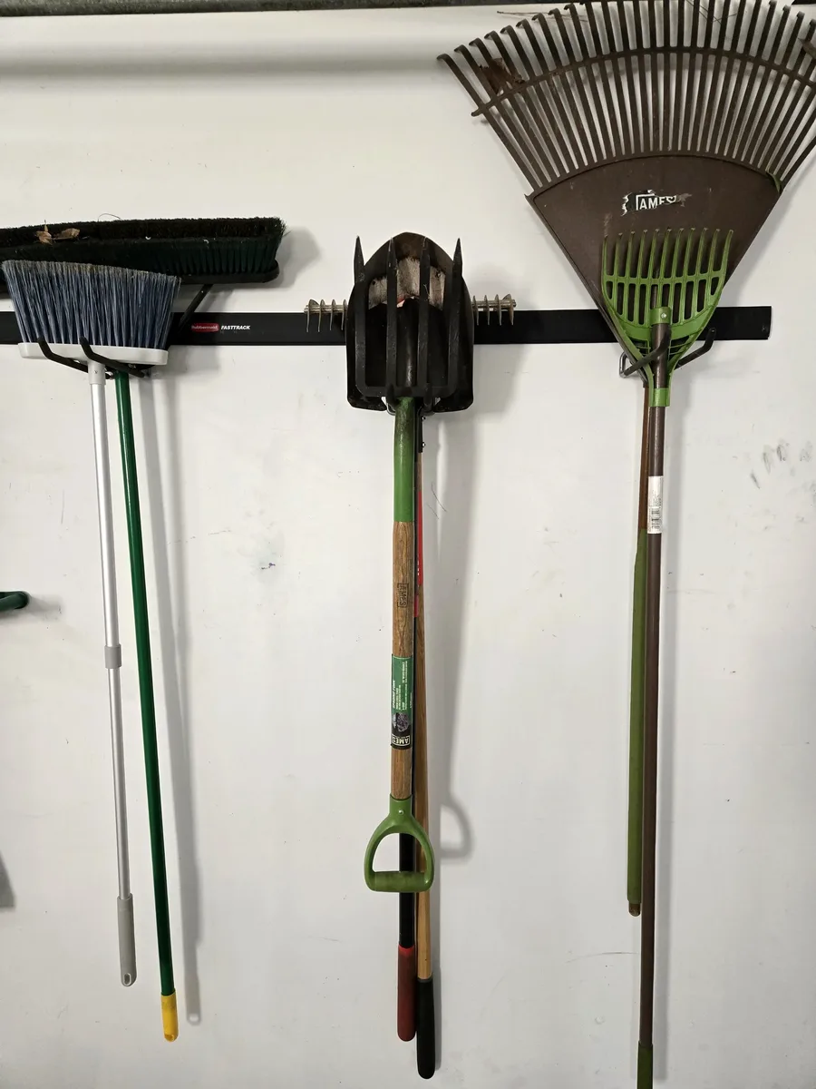 Rakes, shovels, and brooms organized on FastTrack multi-purpose hooks