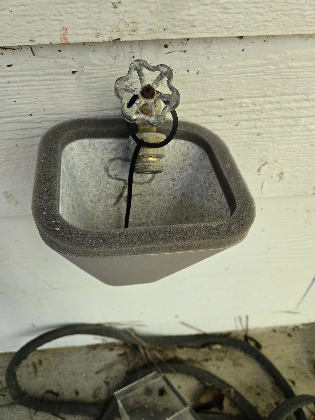The cinch loop inside the cover hooks over the faucet before the shell goes against the wall