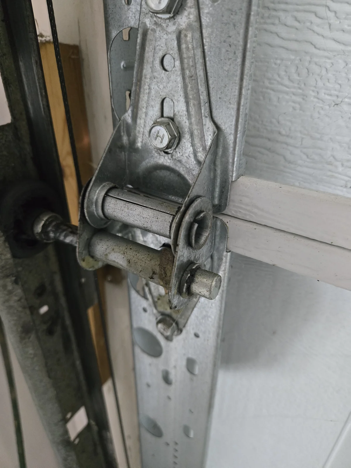 End hinge with the roller stem — spray the bearing where the stem enters the roller, then spin it