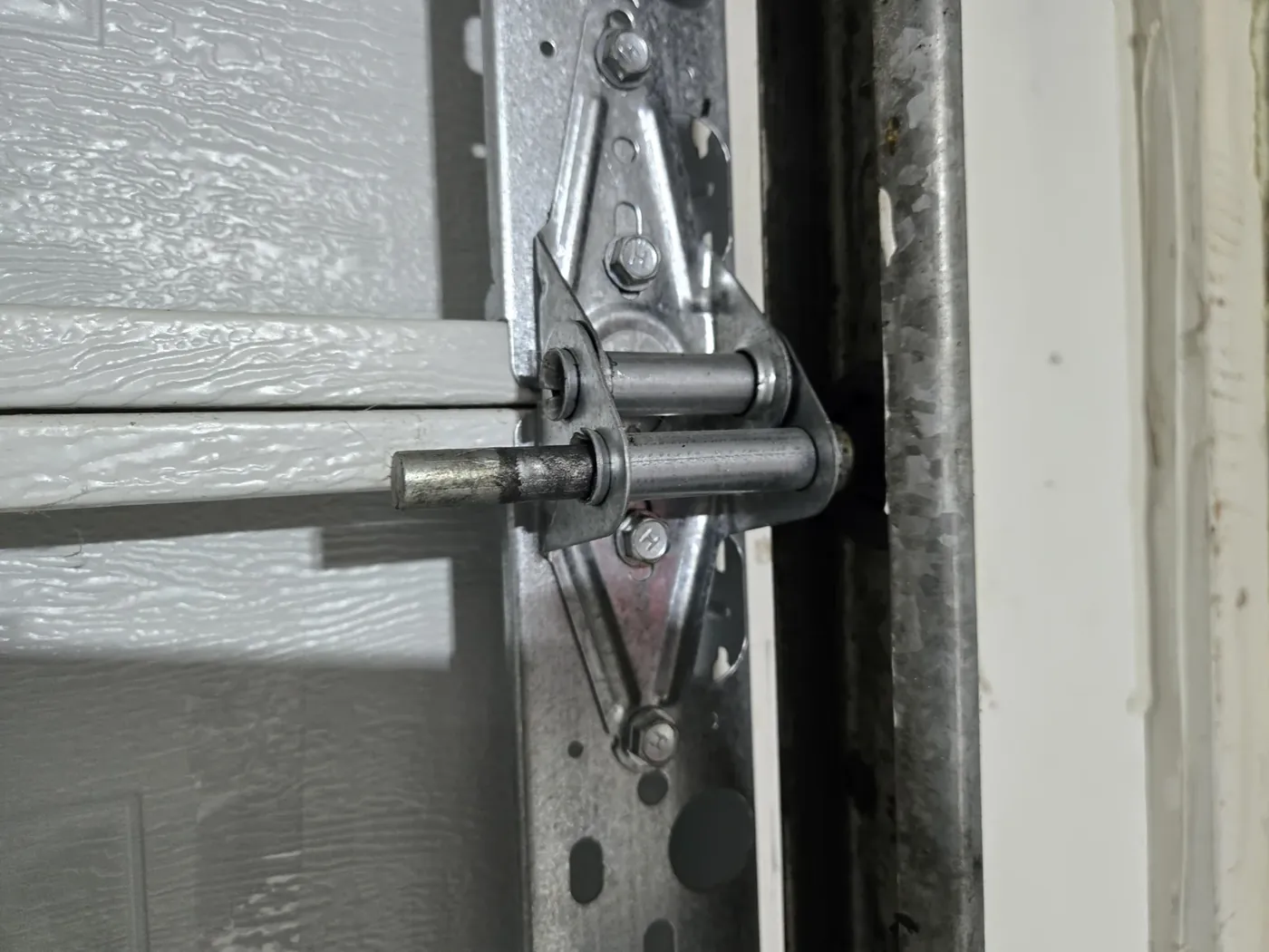 The same routine on an older door — hinges and rollers this old still quiet right down