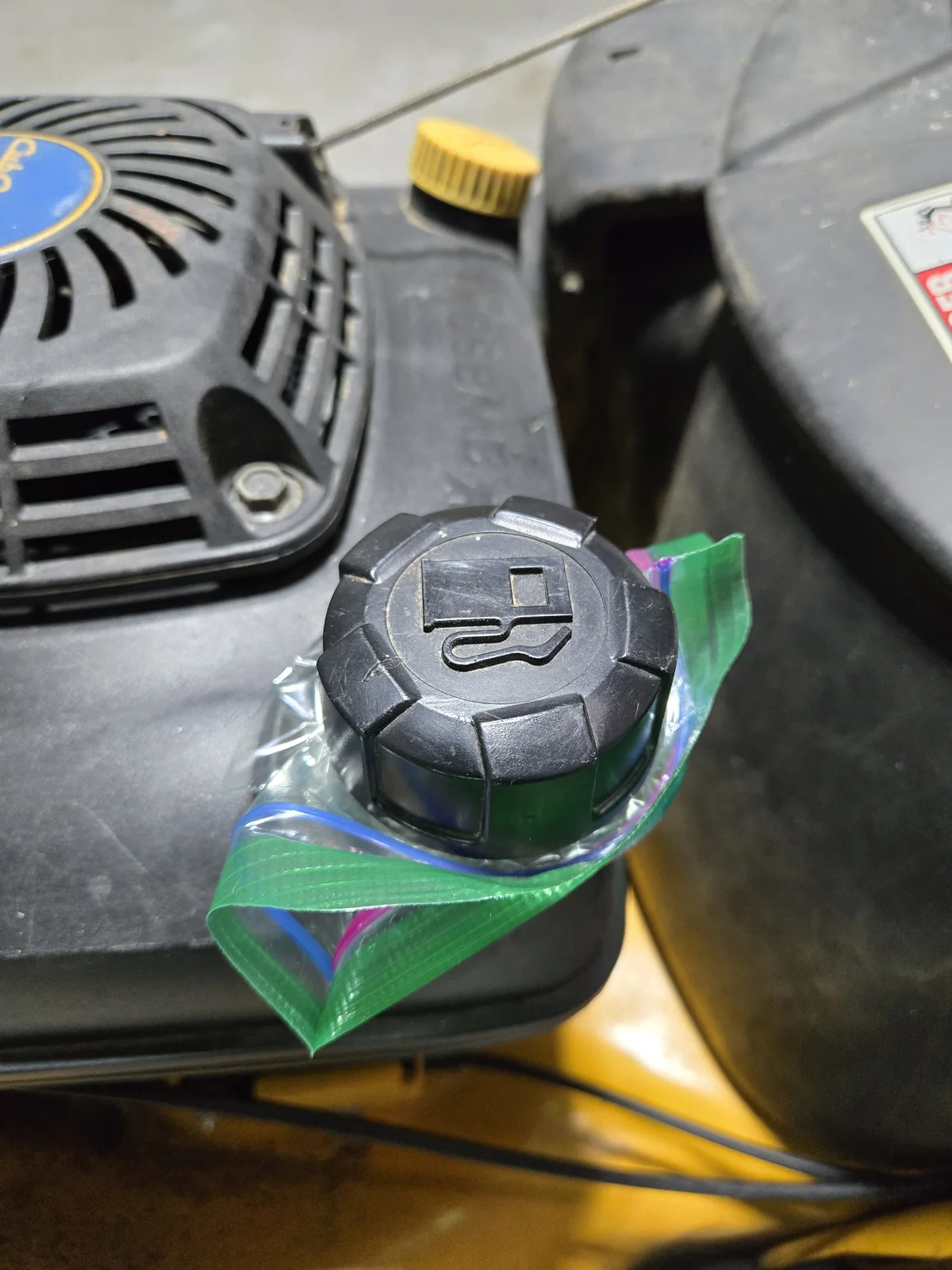 Sandwich bag sealed under the gas cap so fuel can't leak out the vent while the mower is tipped