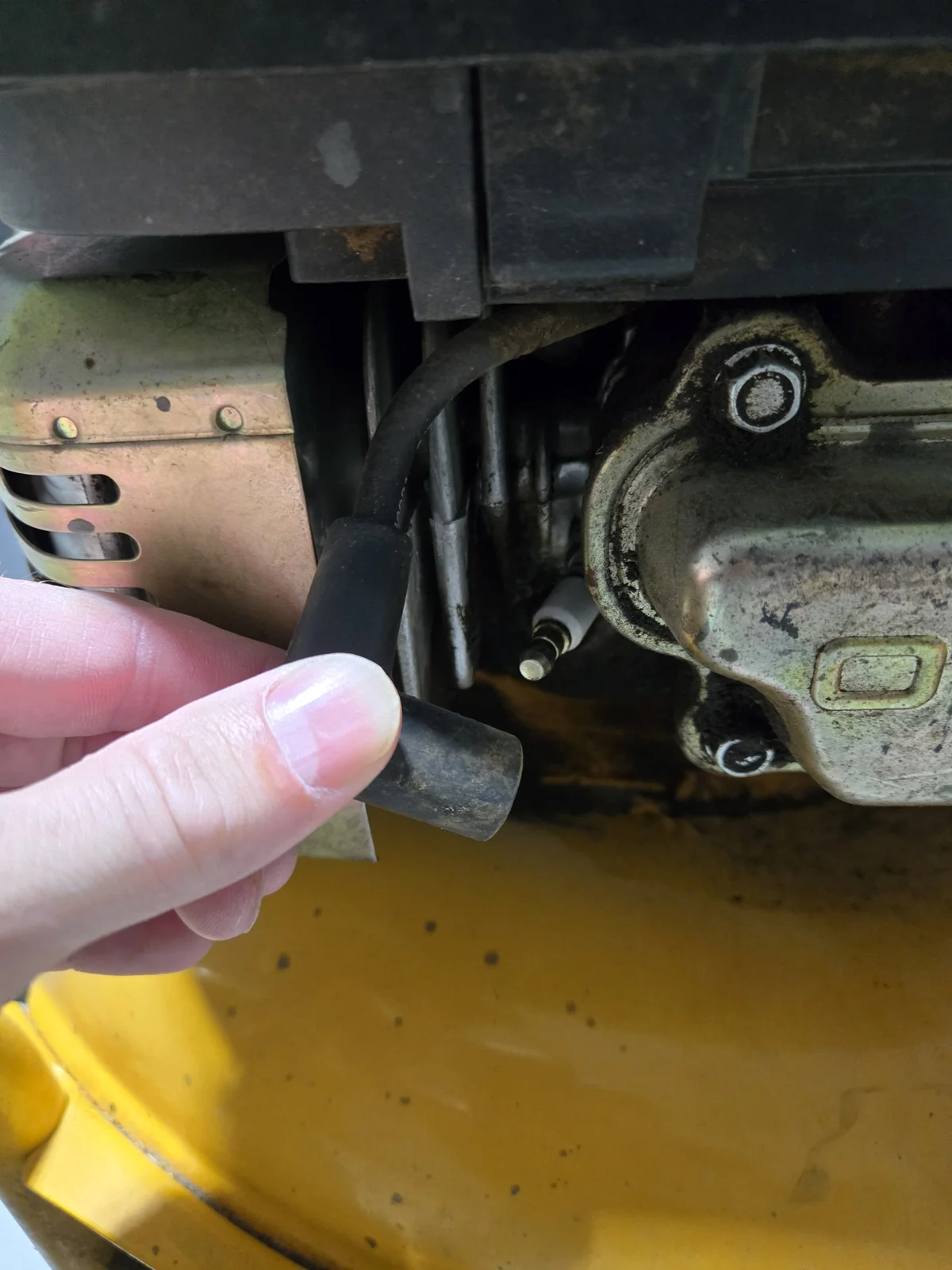 Spark plug boot pulled off the Kawasaki engine before touching the blade
