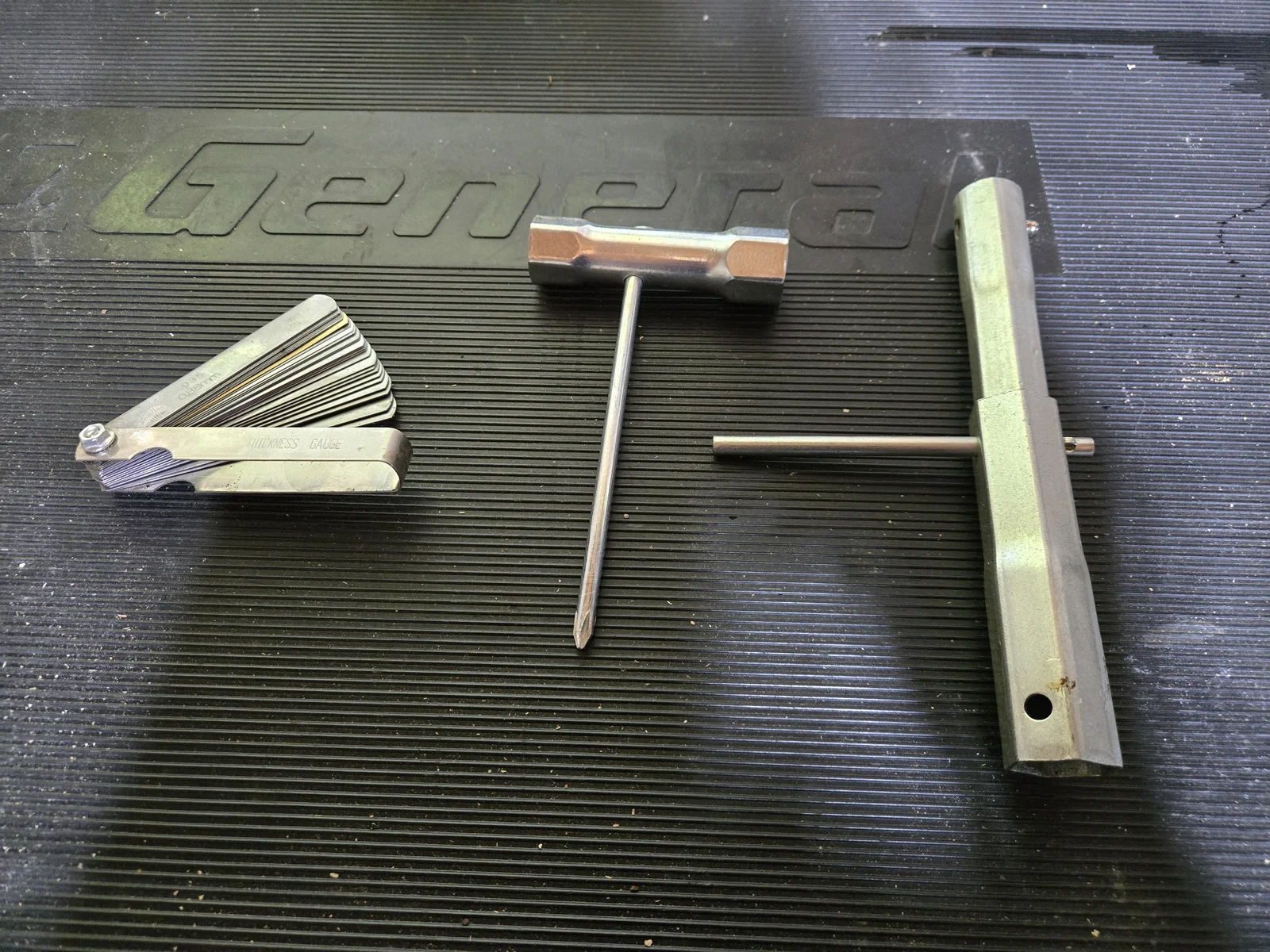 The three tools I use for spark plug work: feeler gauge (left), gap setting tool (middle), spark plug socket wrench (right)
