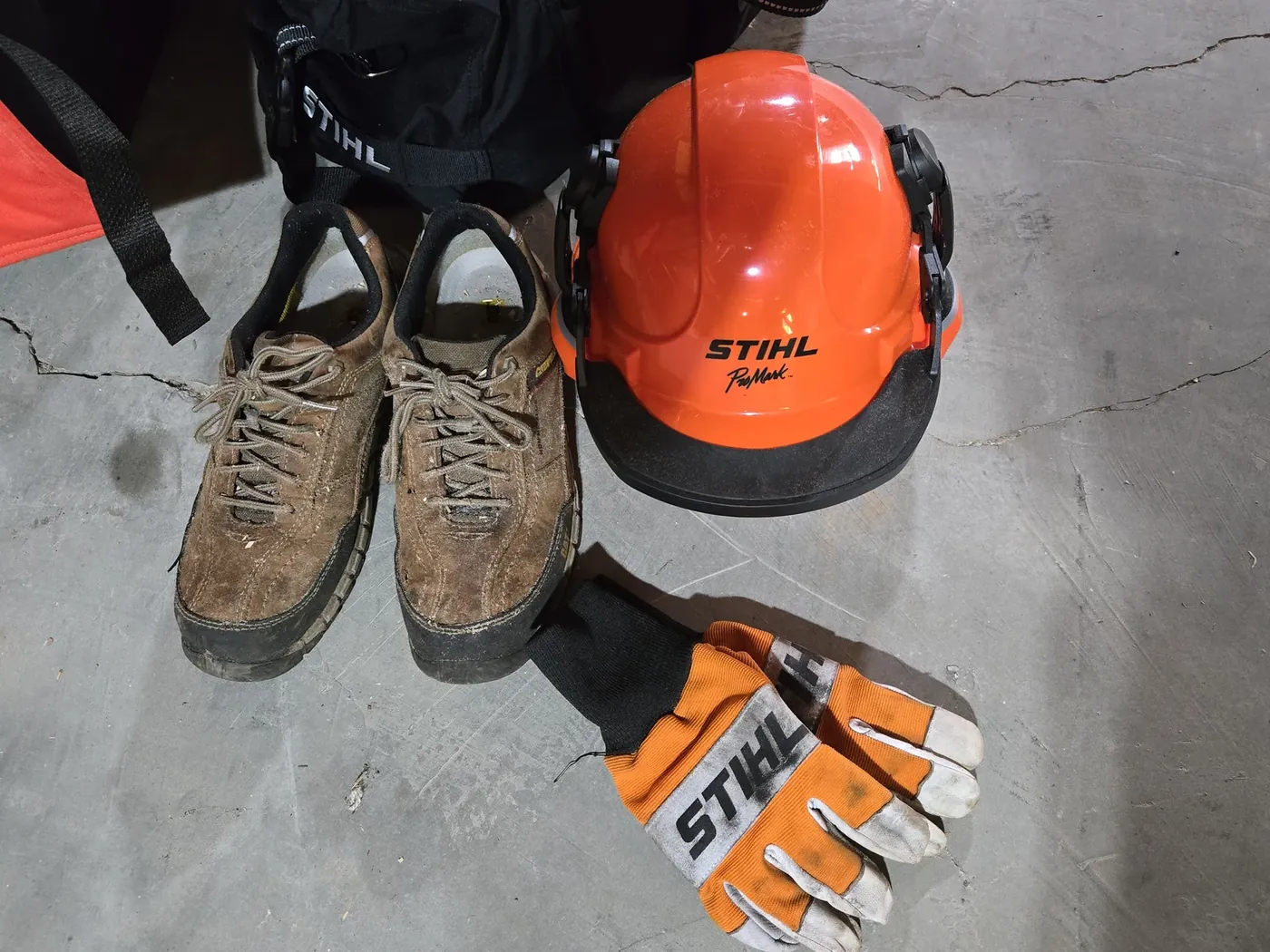 Steel-toe boots, Stihl helmet with face screen and ear muffs, and Stihl gloves