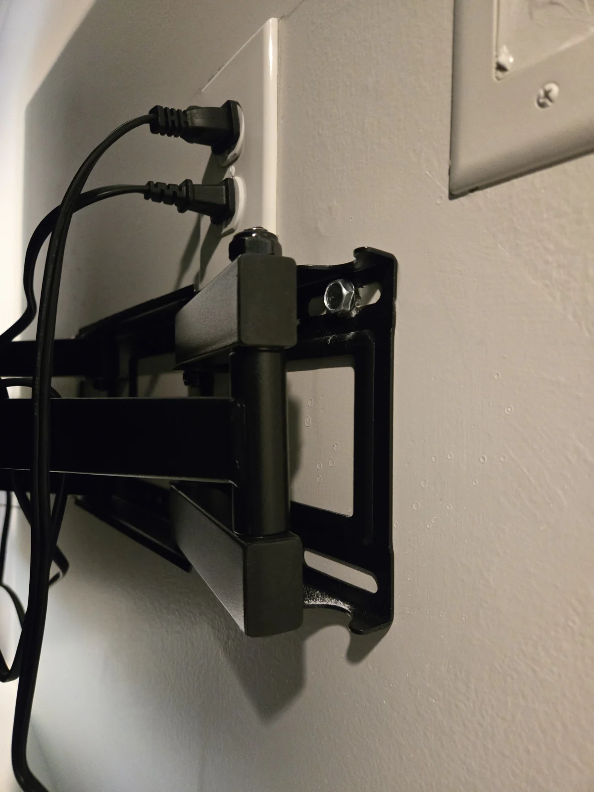 Lag bolt driven through TV mount bracket into wall stud, washer flush against the bracket